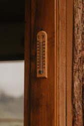 A Wooden Thermometer on a Wall as we answer the ideal temperatures to grow kentucky bluegrass.